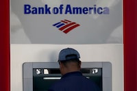File - A customer uses an ATM at a Bank of America location in San Francisco, Monday, April 24, 2023. Bank of America is being ordered to pay more than $100 million to customers for double-dipping on some fees imposed on customers, withholding reward bonuses explicitly promised to credit card customers, and misappropriating sensitive personal information to open accounts without customer knowledge or authorization. (AP Photo/Jeff Chiu, File)