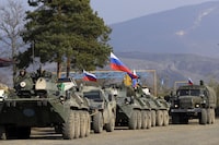 FILE - Russian peacekeepers' vehicles are parked at a checkpoint on the road to Shusha in the separatist region of Nagorno-Karabakh, on Tuesday, Nov. 17, 2020. President Vladimir Putin's spokesman said Wednesday April 17, 2024 that Russian forces are being withdrawn from Azerbaijan's Karabakh region, where they have been stationed as peacekeepers since the end of a war in 2020. (AP Photo/Sergei Grits, File)