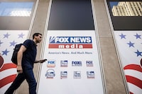 FILE - A person walks past the Fox News Headquarters in New York on April 12, 2023. Fox Corp. swung to a third quarter loss Tuesday, May 9, weighed down by Fox News' nearly $800 million settlement with Dominion Voting Systems. (AP Photo/Yuki Iwamura, File)