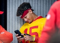 Kansas City Chiefs quarterback Patrick Mahomes checks his mobile phone before attending a press conference in Frankfurt, Germany, Friday, Nov. 3, 2023. The Kansas City Chiefs are set to play the Miami Dolphins in a NFL game in Frankfurt on Sunday Nov. 5, 2023. (AP Photo/Michael Probst)
