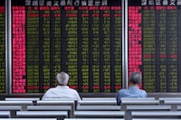 Investors monitor stock prices at a brokerage in Beijing Tuesday, June 25, 2019.
