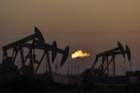 FILE - A flare burns off methane and other hydrocarbons as oil pumpjacks operate in the Permian Basin in Midland, Texas, Tuesday, Oct. 12, 2021. Under the Biden administration's Inflation Reduction Act, companies must start producing precise measurements of their methane emissions next year or face fines. (AP Photo/David Goldman, File)