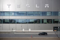 A vehicle from the security service drives by the Tesla car factory after production came to a standstill and workers were evacuated following a power outage, in Grünheide, Germany, Tuesday, March 5, 2024. (Sebastian Gollnow/dpa via AP)