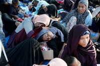 Ethnic Rohingya women rest under a tent after landing on a beach in Kuala Besar, North Sumatra, Indonesia, Sunday, Dec. 31, 2023. Dozens of likely Rohingya refugees, mostly hungry and weak women and children, were found on a beach in Indonesia's North Sumatra province after weeks at sea, officials said on Sunday. (AP Photo/Dedy Zulkifli)