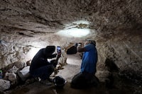Yinon Shivtiel, a historian at Zefat Academic College and Uri Berger of the Israel Antiquities Authority (IAA) inspect a marking on the ceiling of a cave, part of an immense underground hideout comprising narrow tunnels and large storage spaces that, according to the IAA, was dug by Jewish villagers nearly 2,000 years ago at a time of revolt against the Roman Empire, in Huqoq, northern Israel April 1, 2024. REUTERS/Ari Rabinovitch