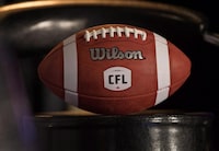 A football with the new CFL logo sits on a chair in Winnipeg, Friday, November 27, 2015. An MP with a long history with the CFL is hoping the league has called an audible in its approach to securing financial help from the federal government. Liberal MP Bob Bratina, who spent 20 years doing play-by-play on Hamilton Tiger-Cats and Toronto Argonauts radio broadcasts before entering politics, is questioning the CFL's strategy. THE CANADIAN PRESS/John Woods