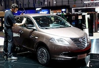 FILE PHOTO: An employee dusts of a Lancia Ypsilon 30th anniversary edition during the first press day ahead of the 85th International Motor Show in Geneva March 3, 2015. REUTERS/Arnd Wiegmann/File Photo