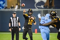 Hamilton Tiger-Cats quarterback Matt Shiltz (18) throws a pass while under pressure by Toronto Argonauts defensive lineman Folarin Orimolade (7) during second half CFL action in Toronto, on Sunday, June 18, 2023. Shiltz signed a one-year deal this month with Calgary.THE CANADIAN PRESS/Christopher Katsarov