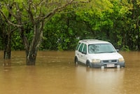 A car inundated with water near the Barron River in Cairns, Australia, Saturday, Dec. 16, 2023. Officials said Monday that more than 300 people have been rescued from floodwaters in northeast Australia, with dozens of residents clinging to roofs. (Joshua Prieto/AAP Image via AP)