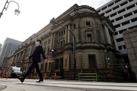 FILE PHOTO: A man walks in front of the headquarters of Bank of Japan in Tokyo, Japan, January 18, 2023.   REUTERS/Issei Kato/File Photo