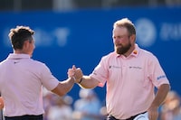 Shane Lowry, of Ireland, right, celebrates with teammate Rory McIlroy, of Northern Ireland, after birdieing the 18th hole to tie for the lead and end their day during the first round of the PGA Zurich Classic golf tournament at TPC Louisiana in Avondale, La., Thursday, April 25, 2024. (AP Photo/Gerald Herbert)