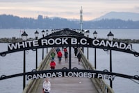 People walk along the pier in White Rock, B.C., Monday, January 17, 2022. Mounties say a man from Surrey has been charged with second-degree murder in a fatal stabbing that shook the community of White Rock, B.C., last month.THE CANADIAN PRESS/Jonathan Hayward
