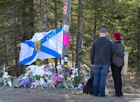 A couple pays their respects at a roadblock in Portapique, N.S. on Wednesday, April 22, 2020.&nbsp;Nova Scotia Premier Tim Houston is asking people to pause for a moment of silence today at noon and again on Wednesday to remember the 22 people killed three years ago during the worst mass shooting in Canadian history. THE CANADIAN PRESS/Andrew Vaughan