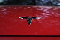 FILE - A Tesla logo is seen on a vehicle on display in Austin, Texas, Feb. 22, 2023. Shares of Tesla tumbled at the opening bell Thursday, Jan. 25, 2024 as the electric vehicle, solar panel and battery maker warned investors of slower sales growth in 2024 after putting up quarterly financial results that were weaker than most had expected. (AP Photo/Eric Gay, File)