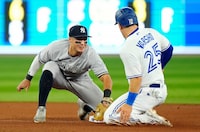 New York Yankees shortstop Anthony Volpe (11) tags out Toronto Blue Jays' Daulton Varsho (25) trying to steal second base during fourth inning MLB American League baseball action in Toronto, on Thursday, May 18, 2023. THE CANADIAN PRESS/Frank Gunn