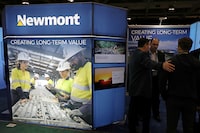 FILE PHOTO: Visitors speak with a representative at the Newmont Corp booth at the Prospectors and Developers Association of Canada (PDAC) annual conference in Toronto, Ontario, Canada March 1, 2020.  REUTERS/Chris Helgren/File Photo