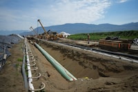 The Calgary Chamber of Commerce is warning the federal government that its proposed cap on emissions from the oil and gas sector could compromise the valuation of the Trans Mountain pipeline. Workers position pipe during construction of the Trans Mountain pipeline expansion in Abbotsford, B.C., on Wednesday, May 3, 2023. THE CANADIAN PRESS/Darryl Dyck