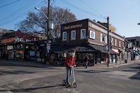 A new report lays out how an innovative funding model for community groups could be scaled up. A man scooters down an empty Kensington Market in Toronto, Wednesday, April 7, 2021. THE CANADIAN PRESS/Tijana Martin