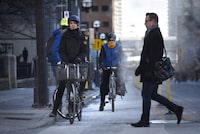 Cyclists on Simcoe St. wait for the traffic signal to change so they can cross King St. West on Jan 11 2016. Even with temperatures well below zero, cyclists in Toronto continue to commute with two wheels on Jan 11 2016. While many put away their bikes in the winter, more and more riders are extending their season well into the cold weather months. (Fred Lum/The Globe and Mail)