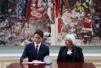 Canadian Prime Minister Justin Trudeau (L), with Governor General of Canada Mary Simon, signs a proclamation on the accession of Britain's King Charles III, during a ceremony at Rideau Hall on September 10, 2022 in Ottawa, Canada.