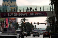 People cross a bridge over the Las Vegas strip Tuesday, Feb. 6, 2024 in Las Vegas. The city will host the Kansas City Chiefs and the San Francisco 49ers in the NFL's Super Bowl 58 football game Sunday. (AP Photo/Charlie Riedel)