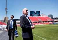 Larry Tanenbaum, right, MLSE chairman, walks on to BMO Field following a press conference in Toronto on Wednesday, May 20, 2015. Bell and MLSE have purchased the Toronto Argonauts plan to relocate the team to BMO Field. THE CANADIAN PRESS/Darren Calabrese