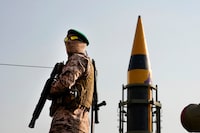 A Revolutionary Guard member stands guard in front of an Iranian domestically built missile displayed during Basij paramilitary force rally in support of the Palestinians in Tehran, Iran, Friday, Nov. 24, 2023. (AP Photo/Vahid Salemi)