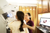 FILE - Mammographer Alma Garcia, right, demonstrates the process of a mammogram on marketing liaison Dalilah Garcia of the Neighbors Emergency Center in Brownsville, Texas, on Monday, Sep. 18, 2017, inside a Mammos on the Move (MOM) mobile mammogram trailer. According to a draft recommendation from a government task force released on Tuesday, May 9, 2023, women should start getting every-other-year mammograms at age 40 instead of waiting until 50. Tuesday’s update – if the draft proposal is finalized – would mark a shift in the influential panel’s guidelines. (Migiuel Roberts/TheBrownsville Herald via AP, File)
