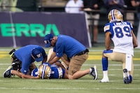 Winnipeg Blue Bombers quarterback Zach Collaros (8) is treated by staff as Kenny Lawler (89) takes a knee against the Edmonton Elks during first half CFL action in Edmonton on Thursday, August 10, 2023. Collaros didn't practise Monday with the Blue Bombers. He suffered an upper-body injury in the first half of Winnipeg's 38-29 comeback road win over the Edmonton Elks on Thursday night. THE CANADIAN PRESS/Jason Franson