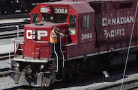 Canadian Pacific Railway Ltd. and Unifor have reached a tentative collective agreement for 1,200 workers who are responsible for maintaining rail cars and locomotives. A Canadian Pacific Railway employee walks along the side of a locomotive in a marshalling yard in Calgary, Wednesday, May 16, 2012. THE CANADIAN PRESS/Jeff McIntosh