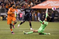 Forge FC forward Beni Badibanga (left) scores past Cavalry FC goalkeeper Marco Carducci during Canadian Premier League final soccer action in Hamilton on Saturday, Oct. 28, 2023. It appears Canadian Soccer Business and Mediapro have solved their broadcast differences. THE CANADIAN PRESS/Nick Iwanyshyn