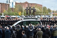 The cortege of English soccer icon Bobby Charlton passes by the statue of Manchester United trio of George Best, left, Denis Law, center, and Sir Bobby Charlton outside Old Trafford stadium on its way to the funeral service at Manchester Cathedral in Manchester, England, Monday, Nov. 13, 2023. Charlton who played largely for Manchester United survived a plane crash that decimated a United team destined for greatness, he went on to became the heartbeat of his country's 1966 World Cup triumph. (AP Photo/Rui Vieira)