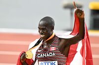 Canada's gold medallist Marco Arop celebrates with his medal and national flag after the men's 800m final during the World Athletics Championships at the National Athletics Centre in Budapest on August 26, 2023. (Photo by Attila KISBENEDEK / AFP) (Photo by ATTILA KISBENEDEK/AFP via Getty Images)