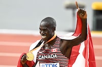 Canada's gold medallist Marco Arop celebrates with his medal and national flag after the men's 800m final during the World Athletics Championships at the National Athletics Centre in Budapest on August 26, 2023. (Photo by Attila KISBENEDEK / AFP) (Photo by ATTILA KISBENEDEK/AFP via Getty Images)