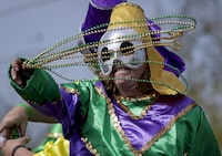 FILE - A rider tosses beads as the Krewe of Argus rolls to the theme 'Argus is Golden,' during its 50th anniversary Tuesday, Feb. 21, 2023, in Metairie, La. It’s a beloved Carnival season tradition in New Orleans — masked riders on lavish floats fling string of beads or other trinkets to parade watchers. But the huge amount of non-biodegradable plastic beads that wind up amid all the other Mardi Gras trash worries environmentalists. (Scott Threlkeld/The Times-Picayune/The New Orleans Advocate via AP, File)
