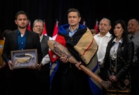 Conservative Leader Pierre Poilievre, centre, is wrapped in a ceremonial blanket and presented a gift alongside the Chief of Tzeachten First Nation, Derek Epp, left, and the Chief of Chippewas of Georgina Island, Donna Big Canoe, right, during a press conference in Vancouver on Thursday, Feb. 8, 2024. Poilievre proposes a plan for First Nations to collect 50 per cent of the federal taxes paid by industrial activities on their land, with industry getting a tax credit in exchange. THE CANADIAN PRESS/Ethan Cairns 