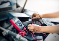 Close up of auto mechanic jumping battery car,check voltage level car battery.