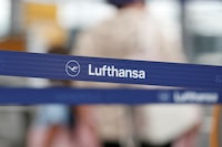 FILE PHOTO: Logo of Lufthansa is seen as passengers wait at Munich Airport in Munich, Germany July 27, 2022. REUTERS/Michaela/File Photo