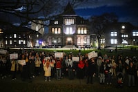 People hold up signs and protest following a vigil held on the grounds of Brown University, after three students of Palestinian descent were shot and wounded in Vermont, at the school's main green in Providence, Rhode Island, U.S. November 27, 2023. REUTERS/Nicholas Pfosi