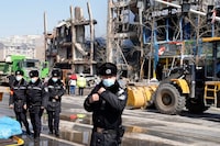 Chinese police officers prepare to clear journalists away from the scene of an explosion in Sanhe city in northern China's Hebei province on Wednesday, March 13, 2024. City officials in eastern China have apologized to local journalists after authorities were shown pushing them and trying to obstruct reporting from the site of a deadly explosion, in a rare acknowledgment of state aggression against journalists. (AP Photo/Ng Han Guan)