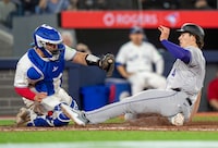 Colorado Rockies right fielder Michael Toglia (4) slides in to score under the tag of Toronto Blue Jays catcher Alejandro Kirk during seventh inning interleague MLB action on Friday April 12, 2024. THE CANADIAN PRESS/Frank Gunn