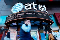 (FILES) In this file photo taken on October 23, 2016 People walk past an AT&T store in New York. 
A federal judge will decide on June 12, 2018 weather a deal between AT&T and Time Warner can go through, a deal that would transform the telecom giant into a media-entertainment powerhouse positioned for a sector facing major technology changes. / AFP PHOTO / KENA BETANCURKENA BETANCUR/AFP/Getty Images