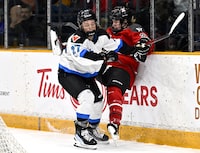 Toronto's Emma Maltais (27) sends Ottawa's Ashton Bell (21) into the boards during first period PWHL hockey action in Ottawa, on Saturday, March 2, 2024. THE CANADIAN PRESS/Justin Tang