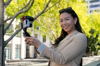 Content creator Cynthia Huang Wang poses near the Embarcadero in San Francisco, Monday, April 8, 2024. Despite a strong job market, there are still thousands of people who have found themselves out of work across industries stretching from tech to retail to media. But rather than trying to find another job in their old role, some workers are turning to online content creation. (AP Photo/Eric Risberg)