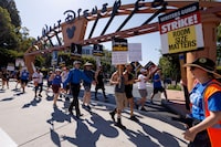 FILE PHOTO: SAG-AFTRA actors and Writers Guild of America (WGA) writers walk the picket line outside Disney Studios in Burbank, California, U.S., July 25, 2023.  REUTERS/Mike Blake/File Photo