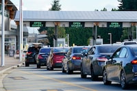A line of vehicles wait to enter Canada at the Peace Arch border crossing Monday, Aug. 9, 2021, in Blaine, Wash.&nbsp;Border-city mayors, tourism industry leaders and an opposition MP say it’s time to bid a less-than-fond farewell to the ArriveCan app.&nbsp;(AP Photo/Elaine Thompson)