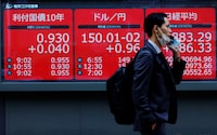 A man walks past an electronic board displaying Japan's 10-year government bonds level, the current Japanese Yen exchange rate against the U.S. dollar and Nikkei share average, outside a brokerage in Tokyo, Japan, October 31.