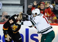 Minnesota Wild forward Marcus Foligno, right, fights with Calgary Flames forward A.J. Greer during second period NHL hockey action in Calgary, Tuesday, Dec. 5, 2023.THE CANADIAN PRESS/Jeff McIntosh