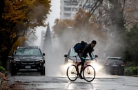 Steam rises from freshly laid asphalt as a person rides a bike in the rain, in Vancouver, B.C., Thursday, Nov. 26, 2020. THE CANADIAN PRESS/Darryl Dyck