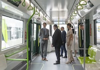Prime Minister Justin Trudeau, left, and Quebec Premier François Legault, centre, enter to ride the new Réseau express métropolitain (REM) light-rail system, on its inaugural run, connecting Brossard, Que., to Gare Centrale, Friday, July 28, 2023, in Brossard. THE CANADIAN PRESS/Christinne Muschi